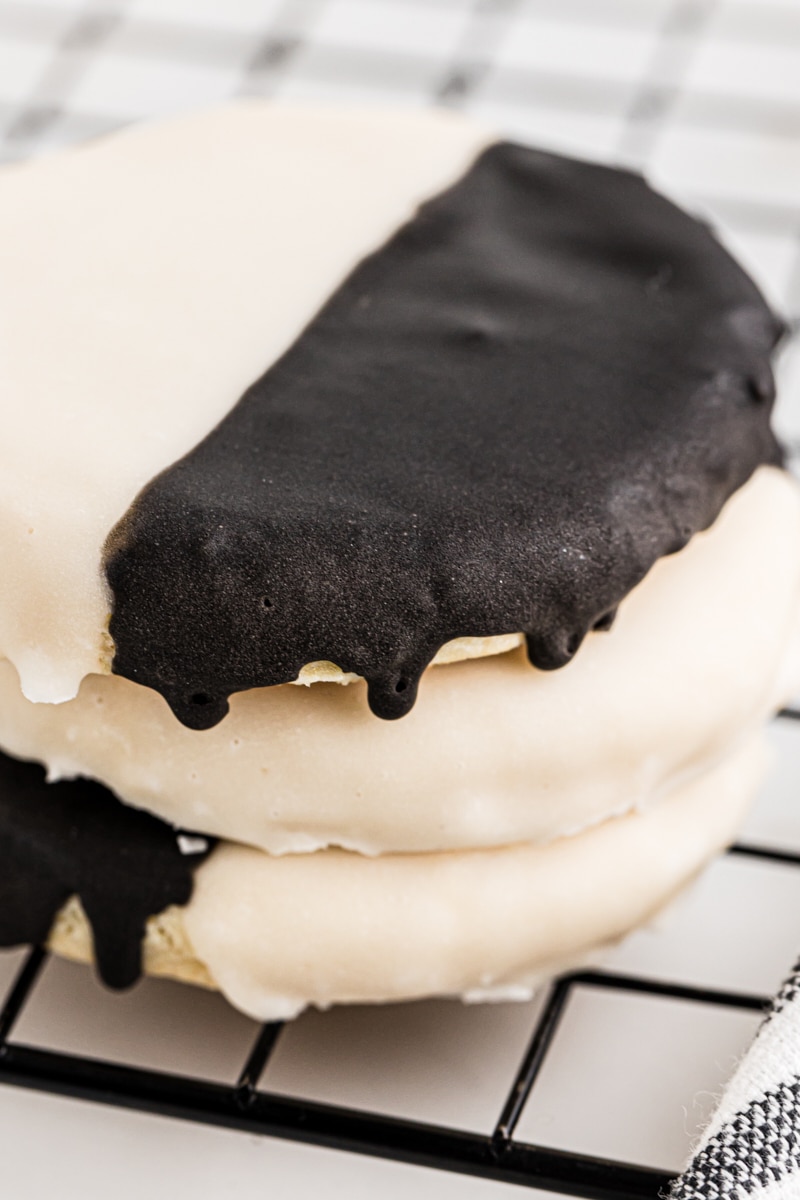 a stack of three black and white cookies on a wire rack