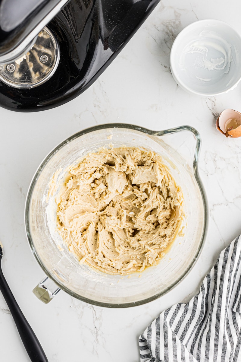 A close-up, overhead view of the perfectly combined black and white cookie dough in a mixing bowl.