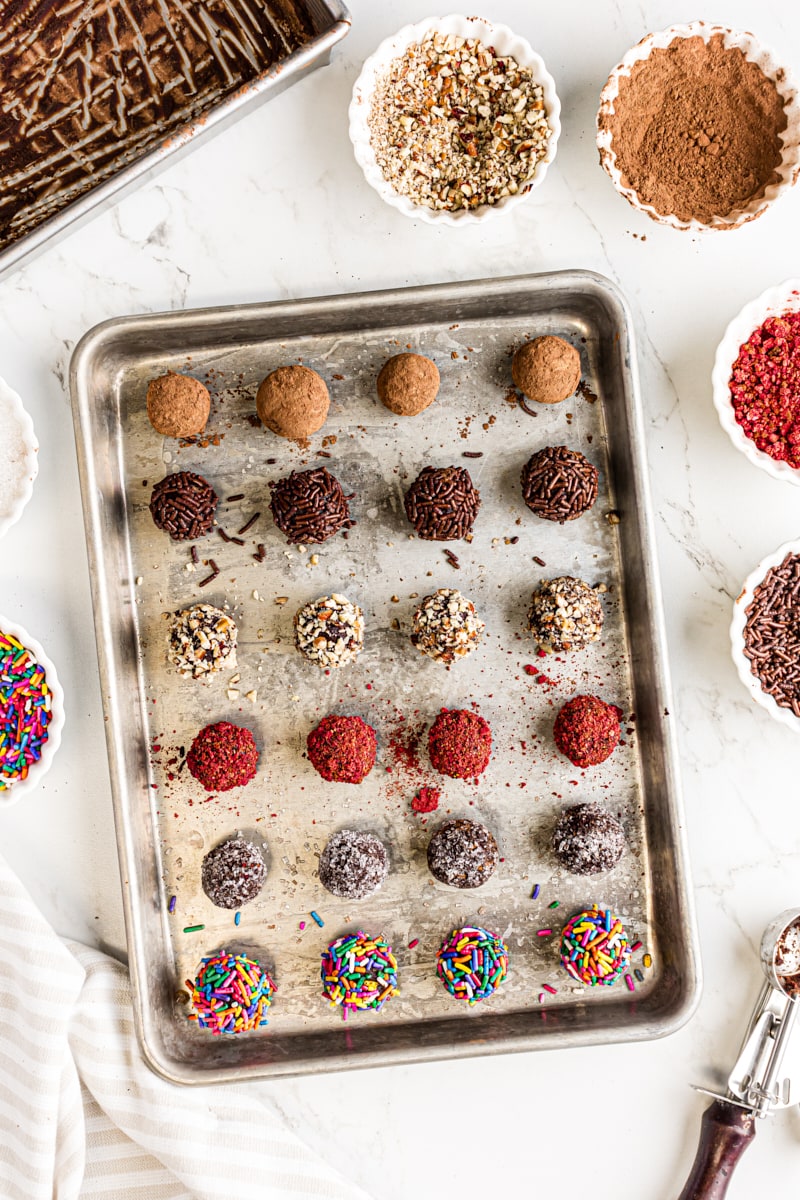 overhead view of chocolate truffles with various coatings placed on a baking sheet