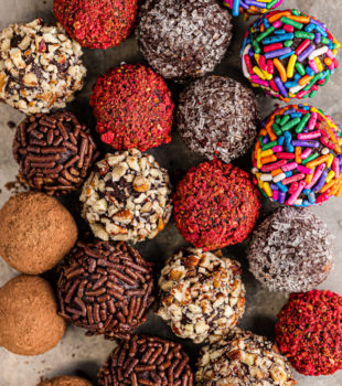 overhead view of chocolate truffles with various coatings on a baking sheet