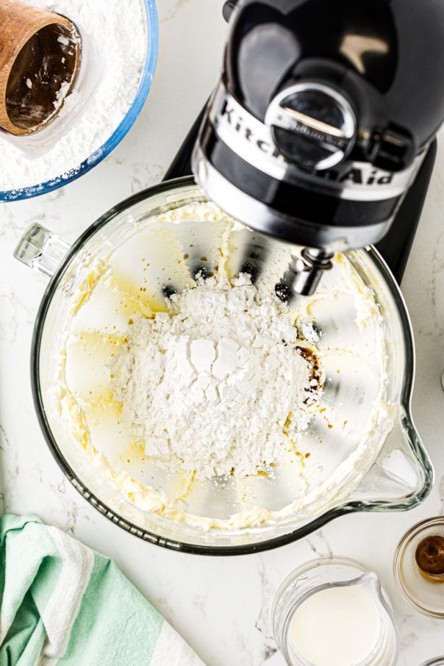 overhead view of confectioners' sugar added to frosting mixture