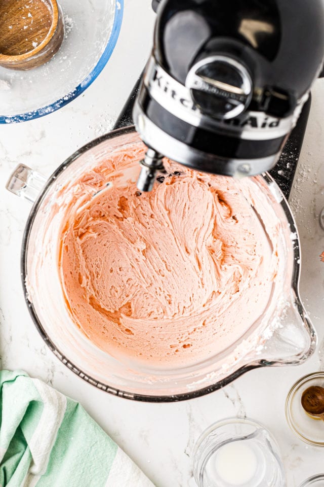 overhead view of pink frosting in the bowl of stand mixer