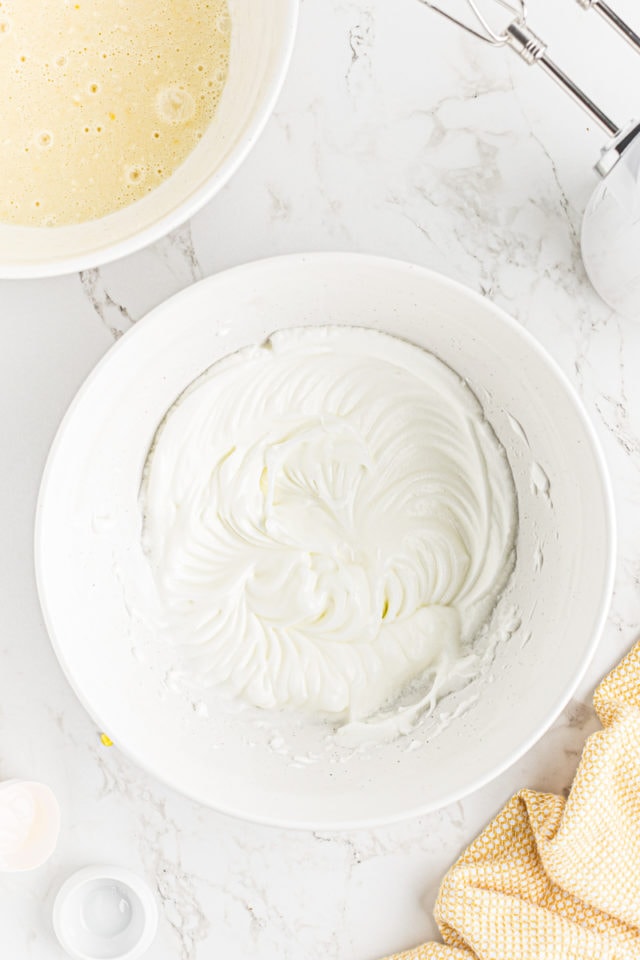 overhead view of whipped egg whites in a mixing bowl