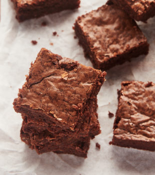 Stacks of fudgy brownies on parchment paper