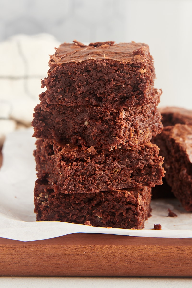 Stack of 4 fudgy brownies on parchment paper
