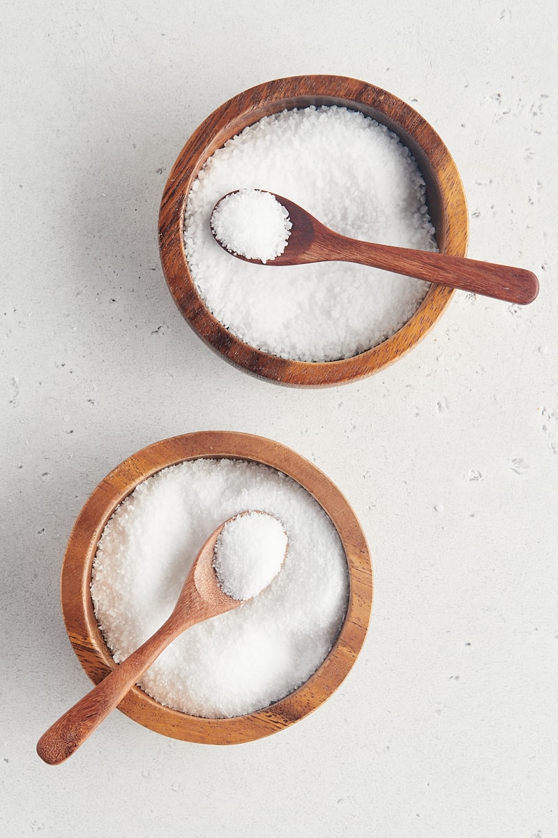overhead view of two wooden bowls filled with kosher salt