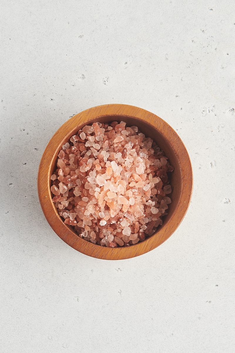 overhead view of Himalayan pink salt in a wooden bowl