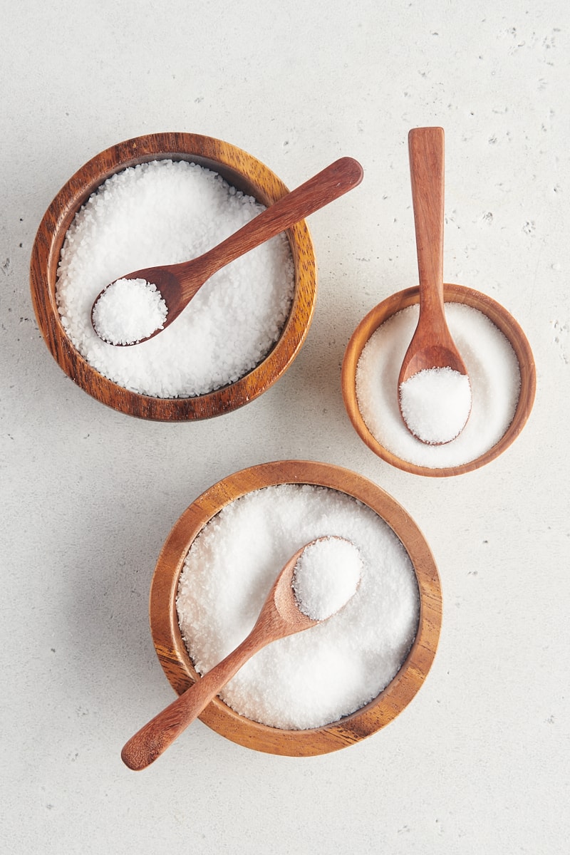 overhead view of three different salts in wooden bowls
