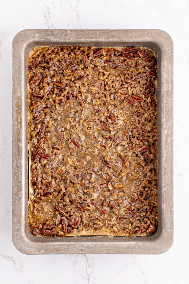 overhead view of partially baked butter pecan turtle bars in a rectangular baking pan