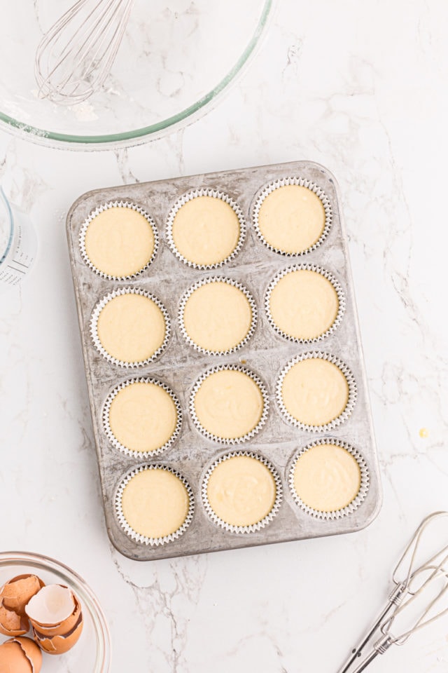 overhead view of vanilla cupcake batter in a muffin pan
