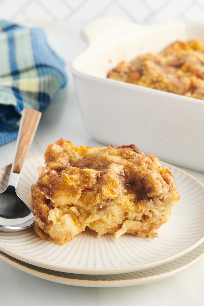 Piece of banana bread pudding on plate with spoon