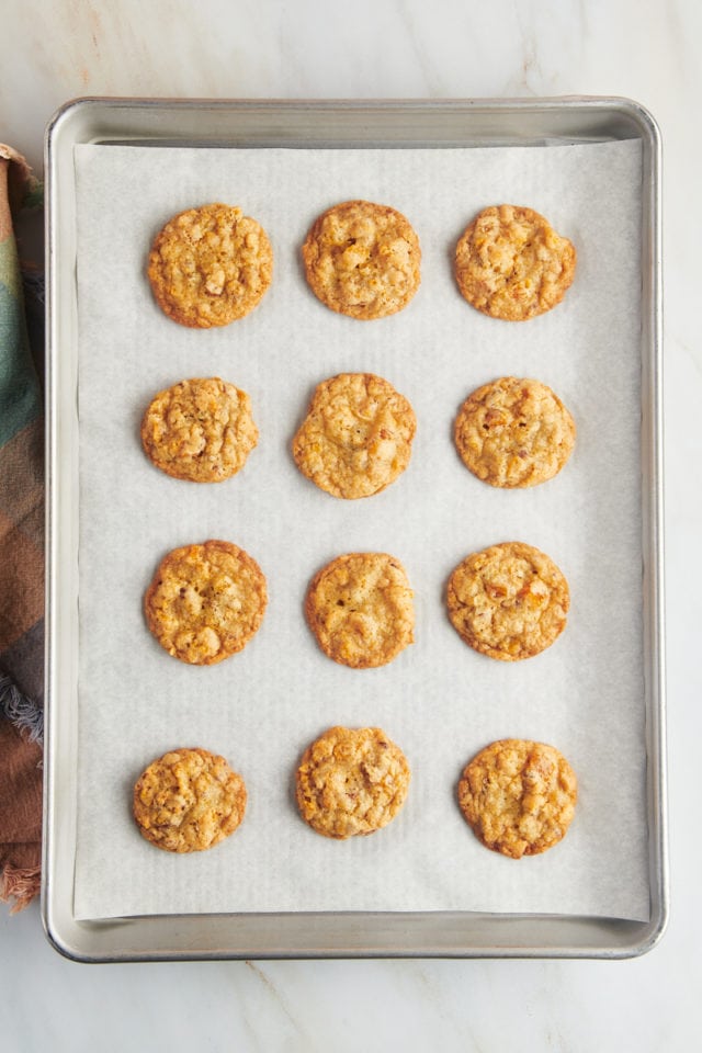 Overhead view of parchment lined baking sheet with cornflake cookies