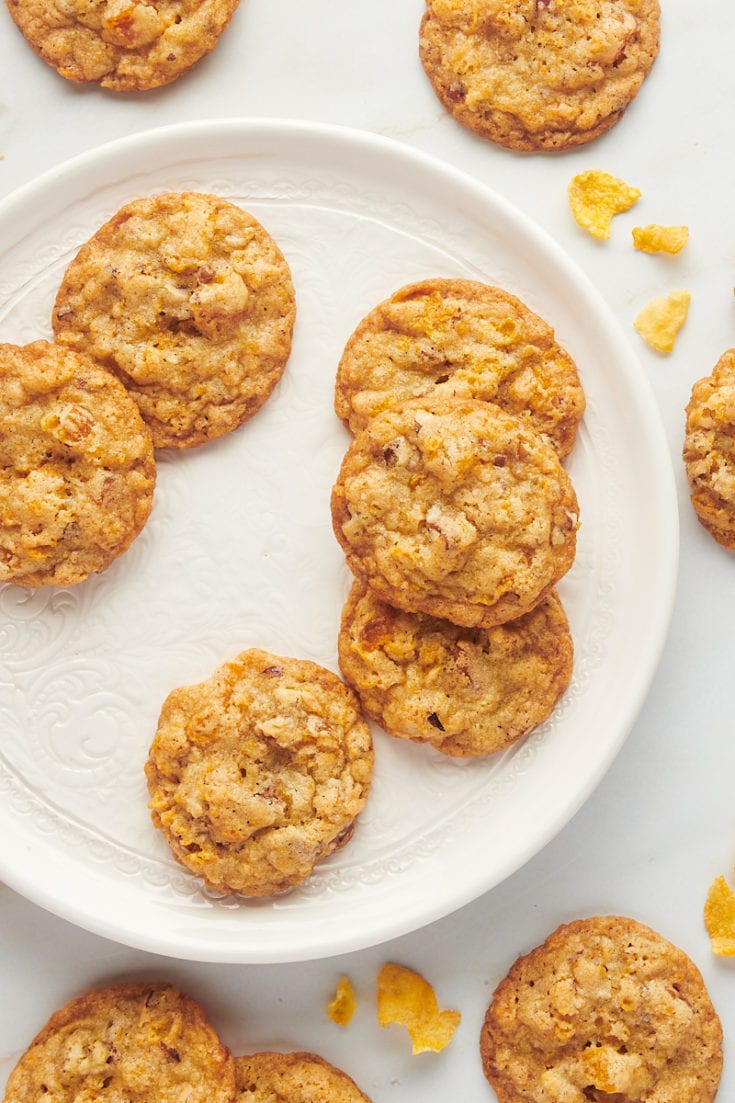 Plate of cornflake cookies with additional cookies on tabletop