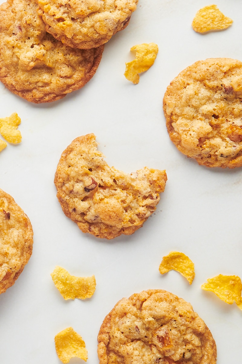 Overhead view of cornflake cookies on countertop with cornflakes scattered around