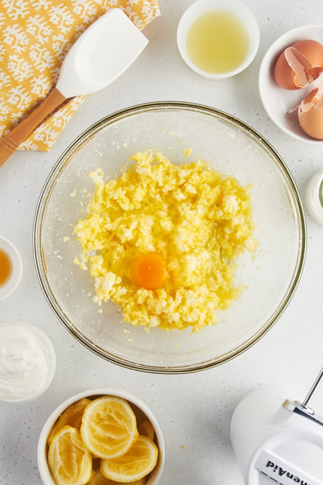 Overhead view of egg cracked into creamed butter and sugar