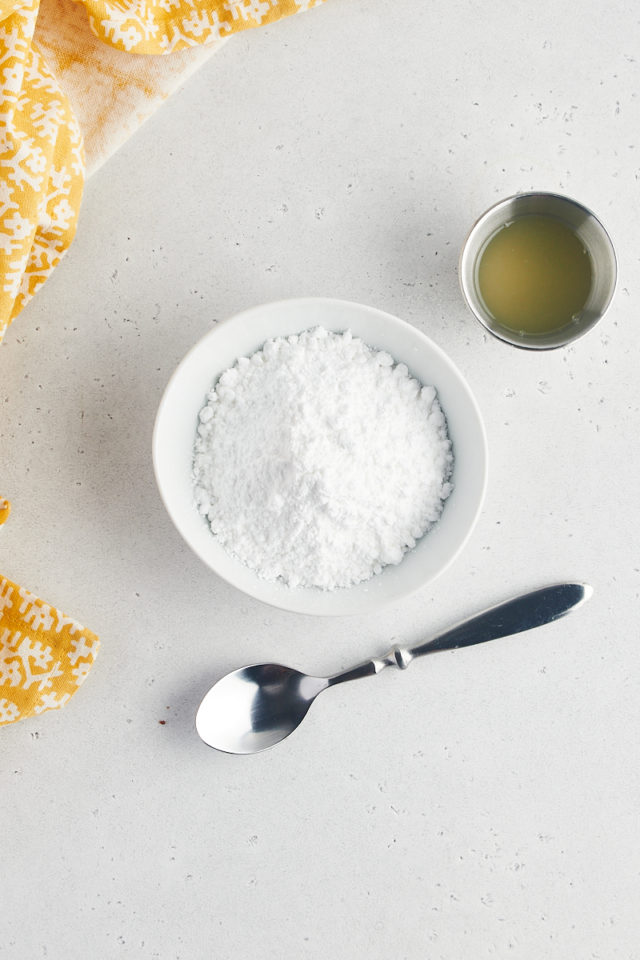 Overhead view of lemon juice and powdered sugar in bowls