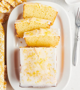 Overhead view of half sliced lemon loaf cake on platter