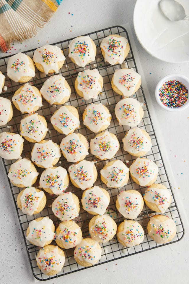 overhead view of sour cream cookies topped with glaze and sprinkles on a wire rack