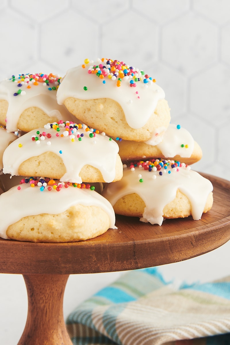 a pile of sour cream cookies on a wooden cake stand