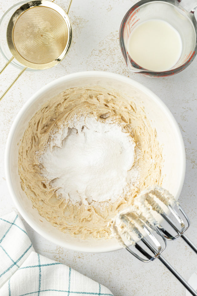 overhead view of confectioners' sugar added to butter-cream cheese mixture