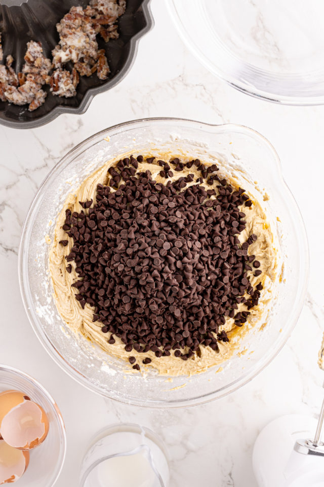 overhead view of chocolate chips added to chocolate chip Bundt cake batter