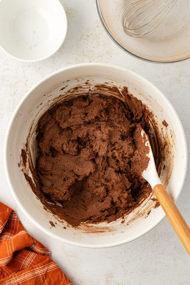 overhead view of mixed chocolate peanut butter cookie dough in a white mixing bowl