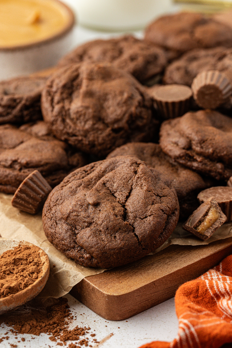 chocolate peanut butter cookies piled on a wooden cutting board