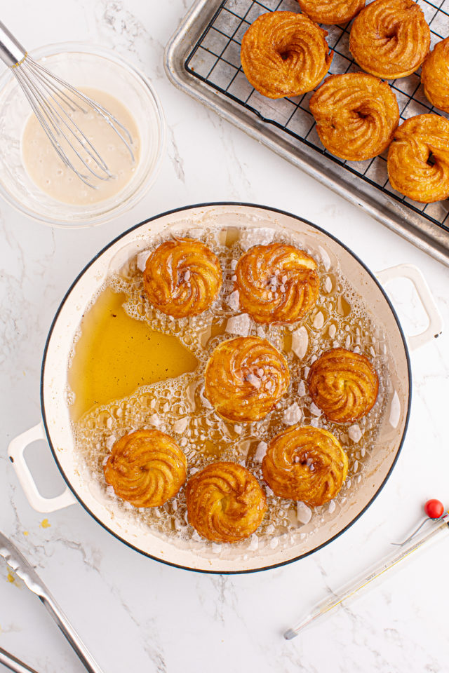 Overhead view of French crullers frying in oil