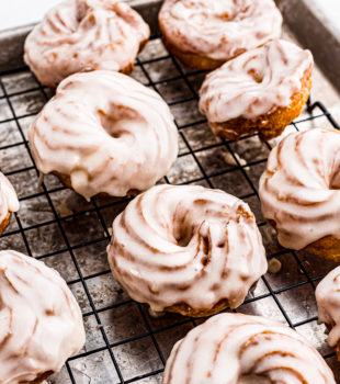 Glazed crullers on wire rack set on seet pan