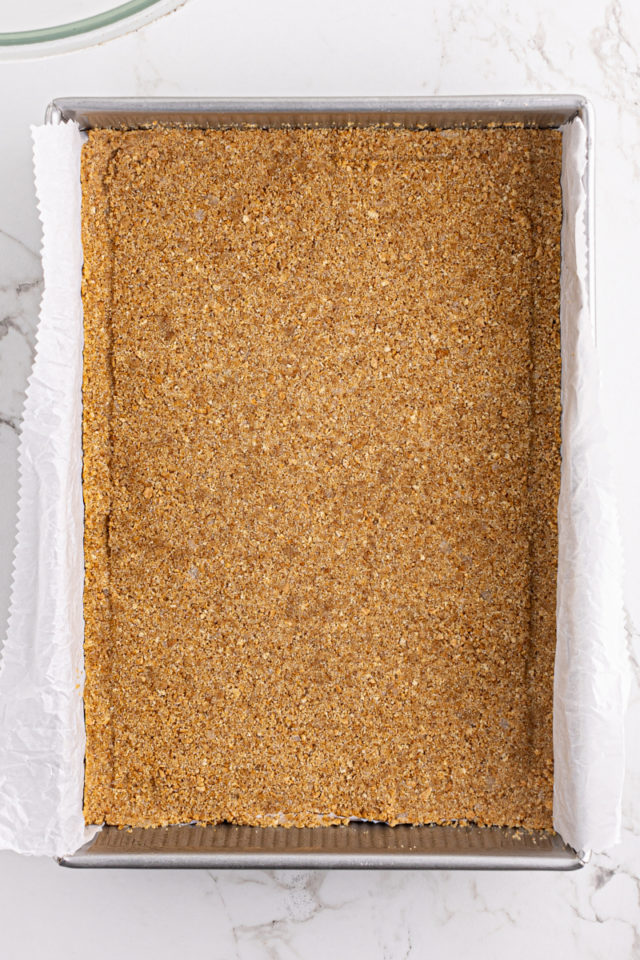 overhead view of a graham cracker crust in a 9x13 baking pan