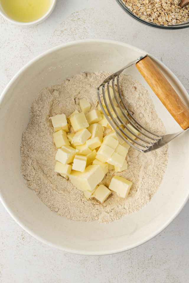 overhead view of butter added to dry ingredients for raspberry oatmeal bars