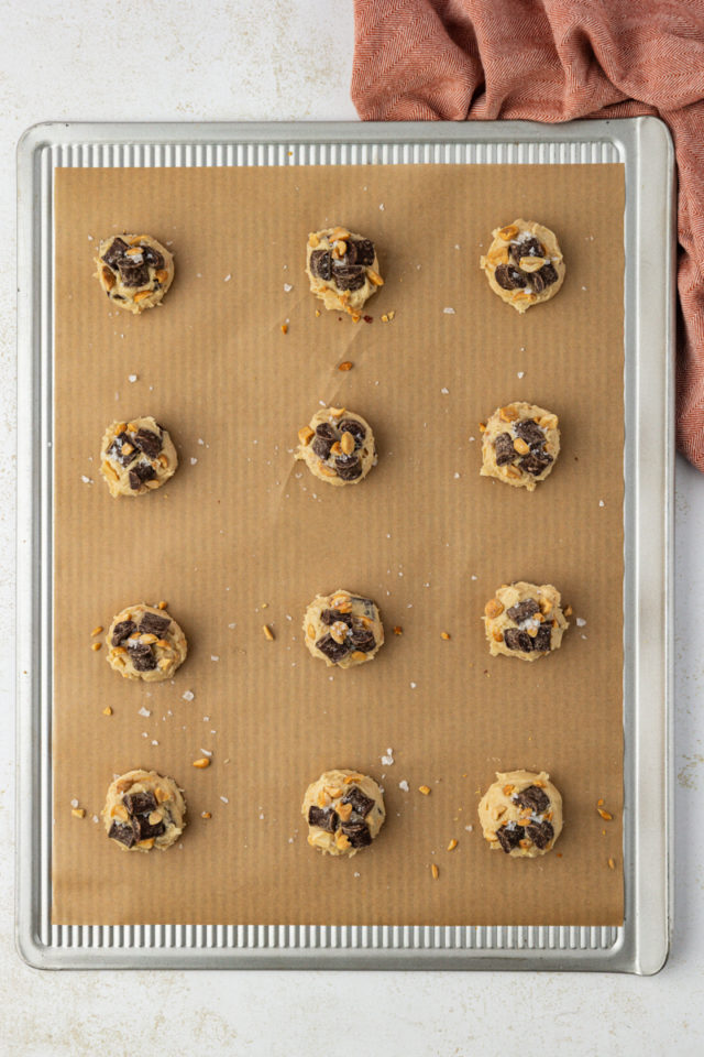 overhead view of peanut chocolate chunk cookie dough on a parchment-lined baking sheet