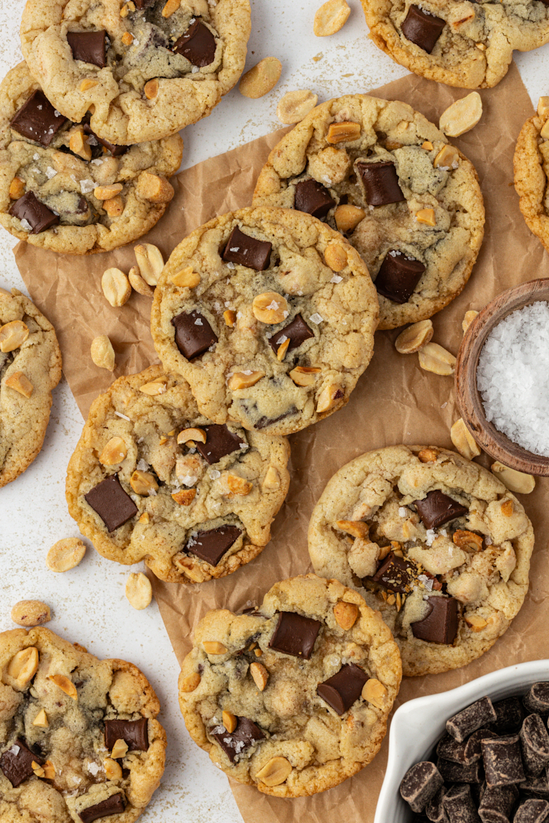 overhead view of peanut chocolate chunk cookies scattered on parchment paper