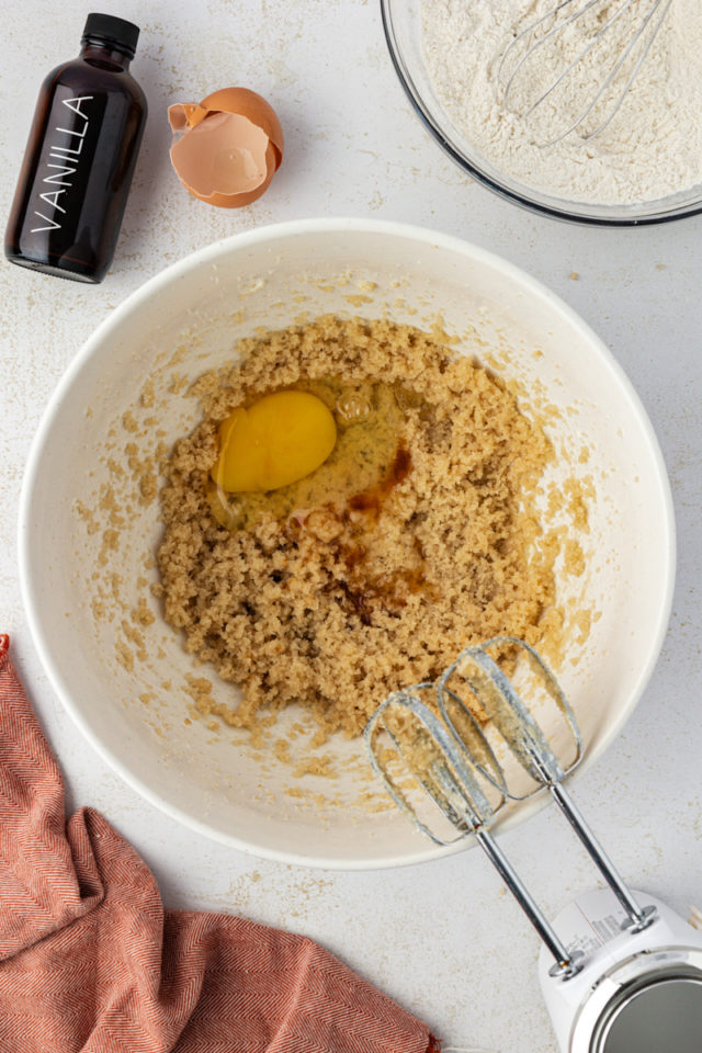 overhead view of egg added to creamed butter and sugars