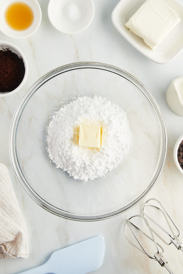 overhead view of confectioners' sugar and butter in a glass mixing bowl
