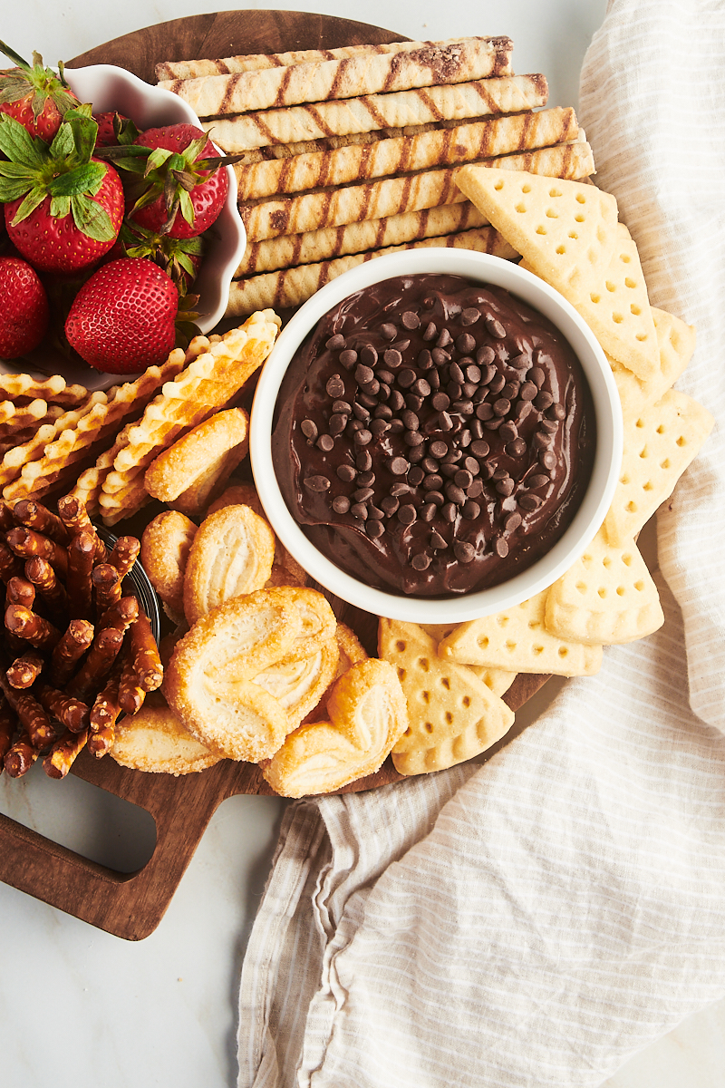 overhead view of brownie batter dip and various dippers on a round wooden board