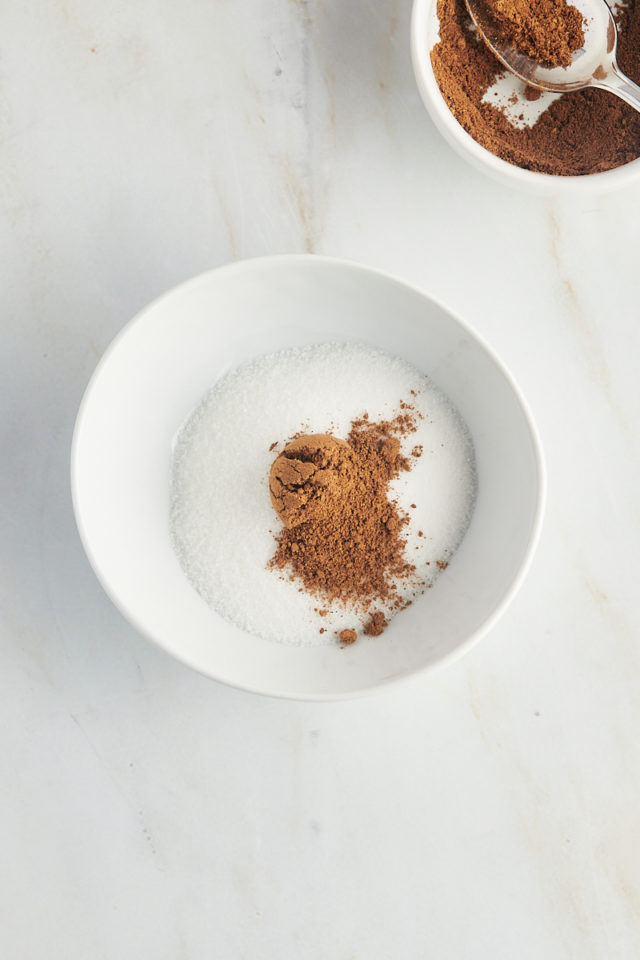 Overhead view of chai spices added to bowl of sugar