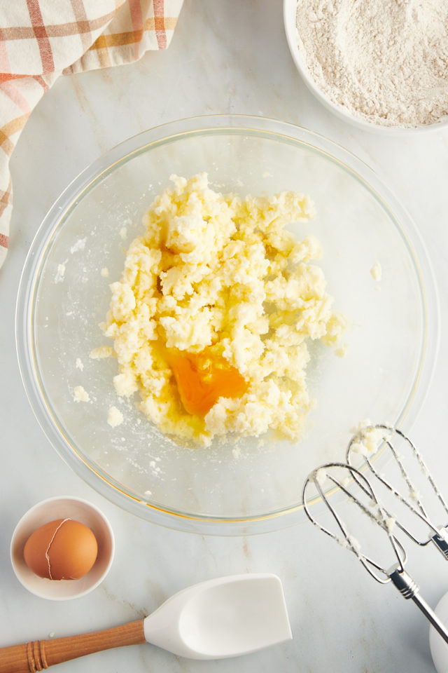Overhead view of egg added to creamed butter and sugar