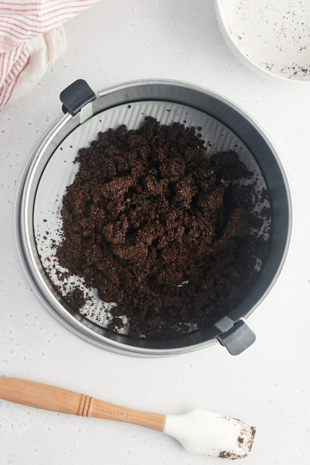 Overhead view of Oreo crust mixture in springform pan