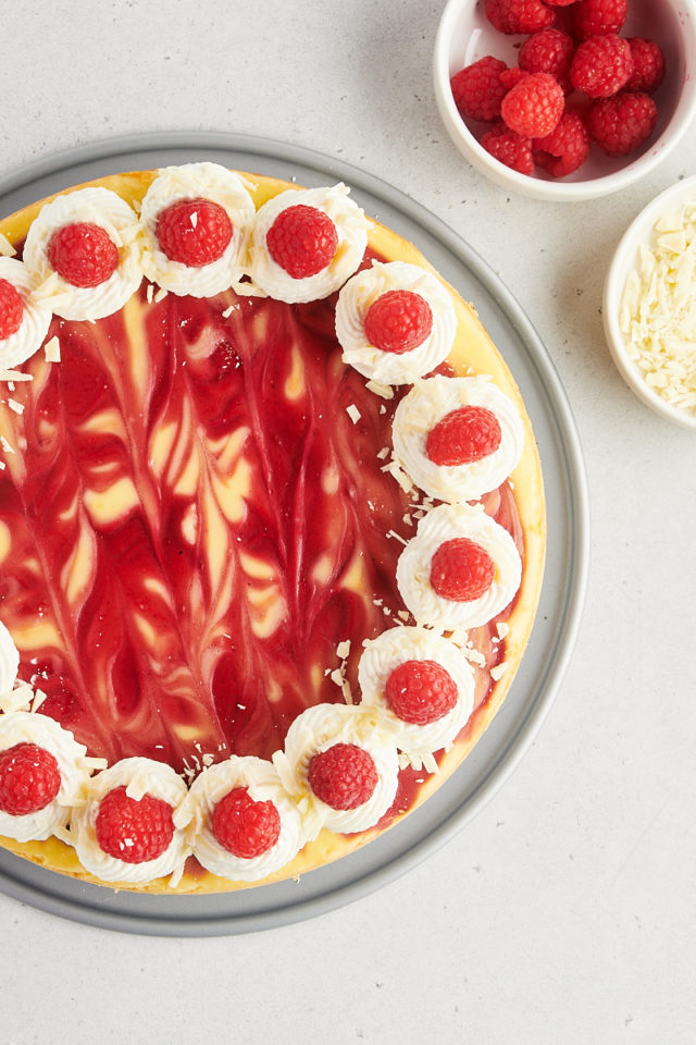Overhead view of decorated white chocolate raspberry cheesecake