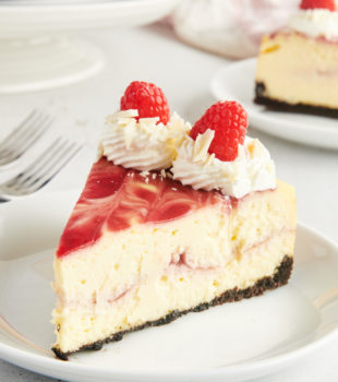 Side view of white chocolate raspberry cheesecake on plate