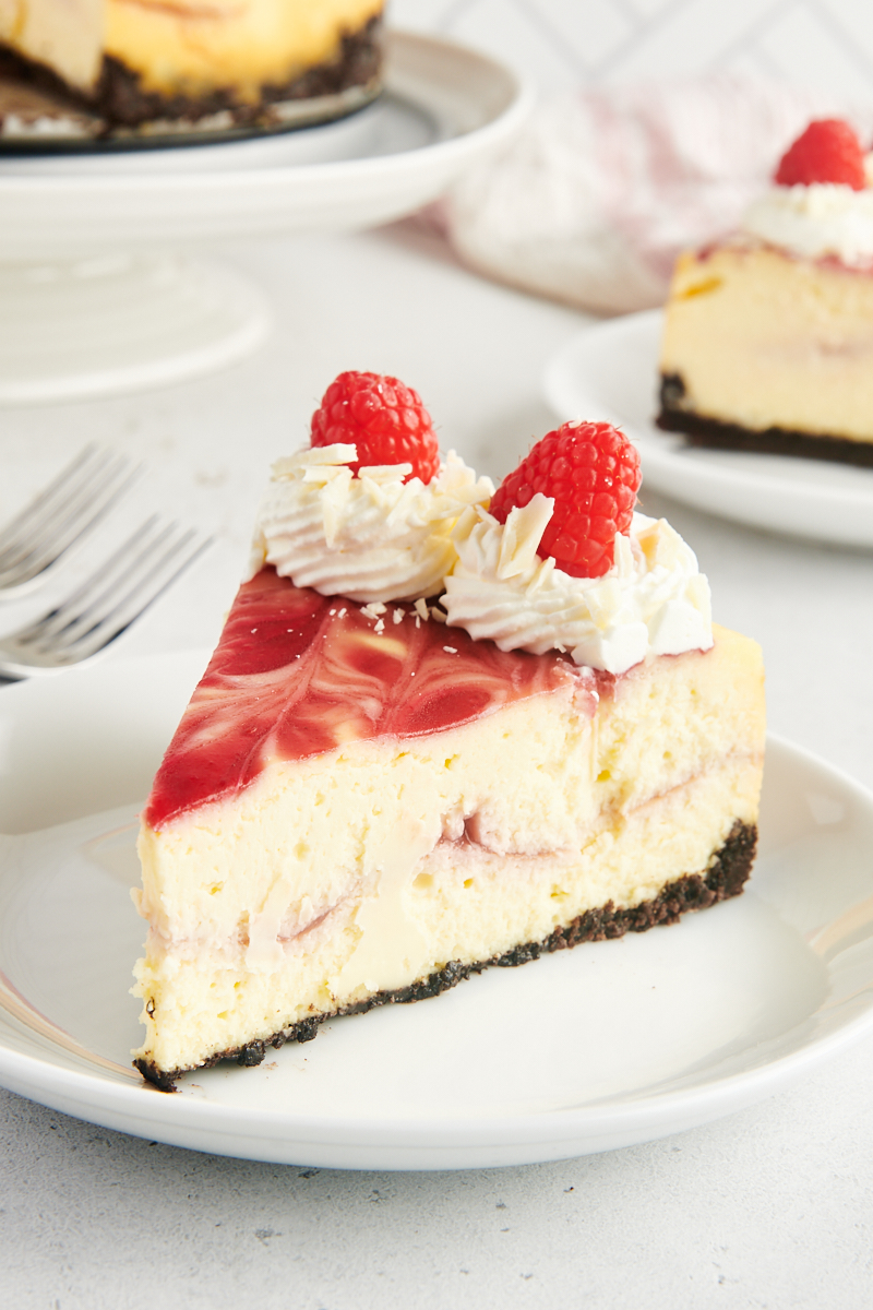 Side view of white chocolate raspberry cheesecake on plate