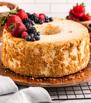 angel food cake topped with fresh berries on a wooden serving tray