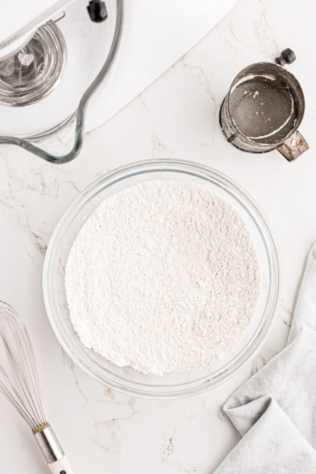 overhead view of sifted cake flour and superfine sugar in a mixing bowl