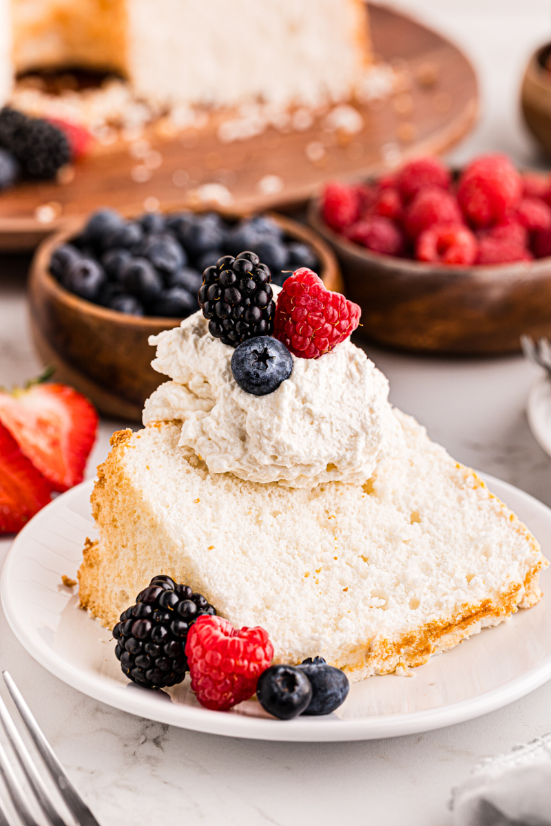 a slice of angel food cake topped with whipped cream and fresh berries