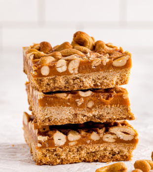 a stack of three butterscotch cashew bars on a marble surface