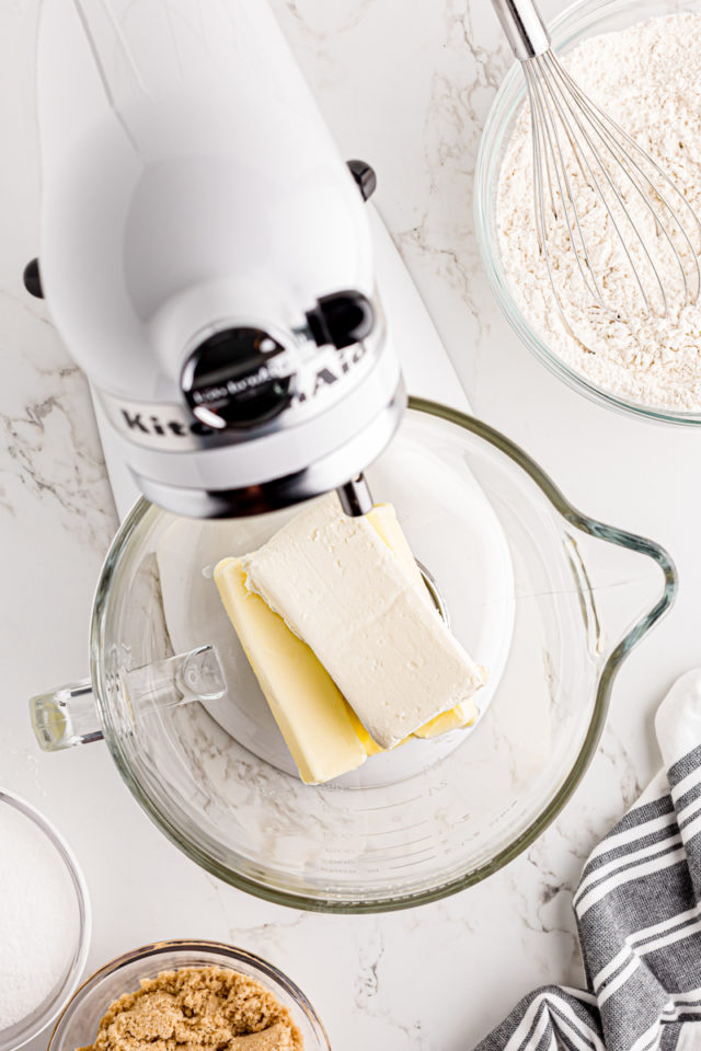 overhead view of butter and cream cheese in the bowl of a stand mixer