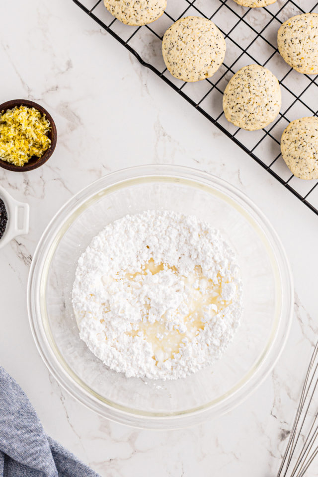 overhead view of confectioners' sugar and lemon juice in a glass mixing bowl