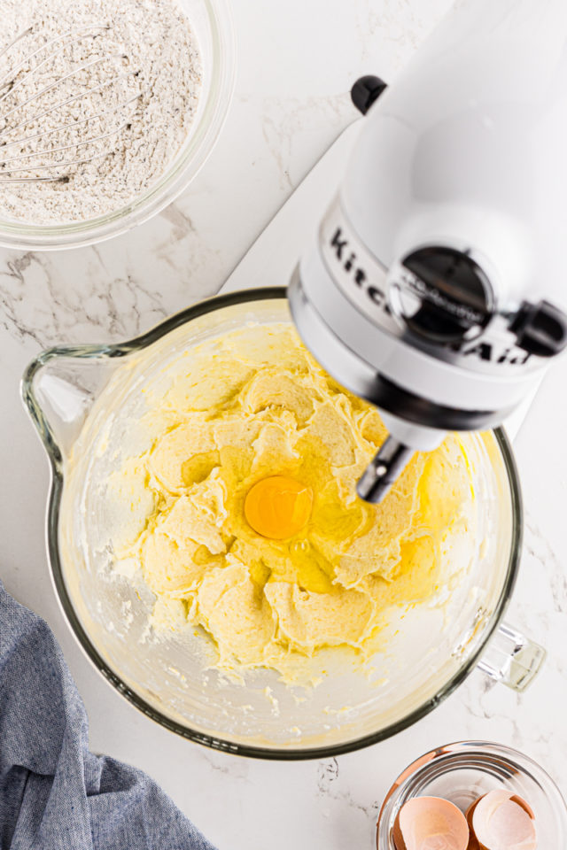 overhead view of egg added to creamed butter and sugar