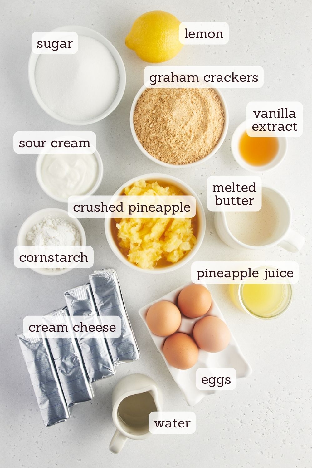 Overhead view of ingredients for pineapple cheesecake with labels